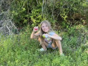 Lexi looking for balls in the weeds.