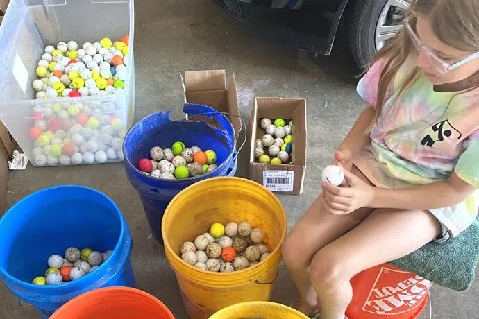 Lexi porter with buckets of golf balls
